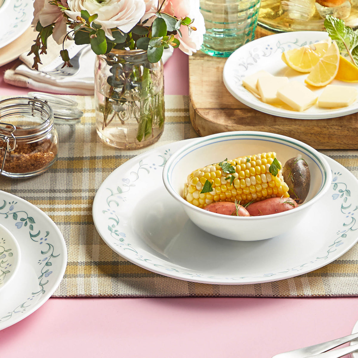 Corelle Country Cottage white dinnerware set with floral graphic design, featuring plates and bowls for everyday use.