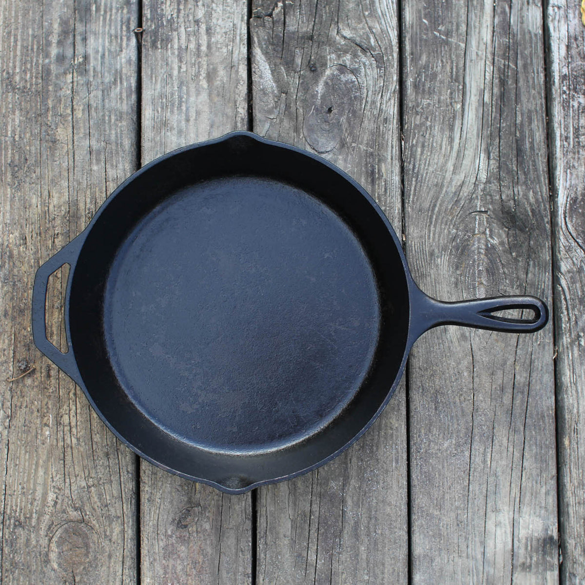 Black LODGE Classic cast iron skillet with handle, ready for cooking, with a smooth cooking surface and sturdy construction.