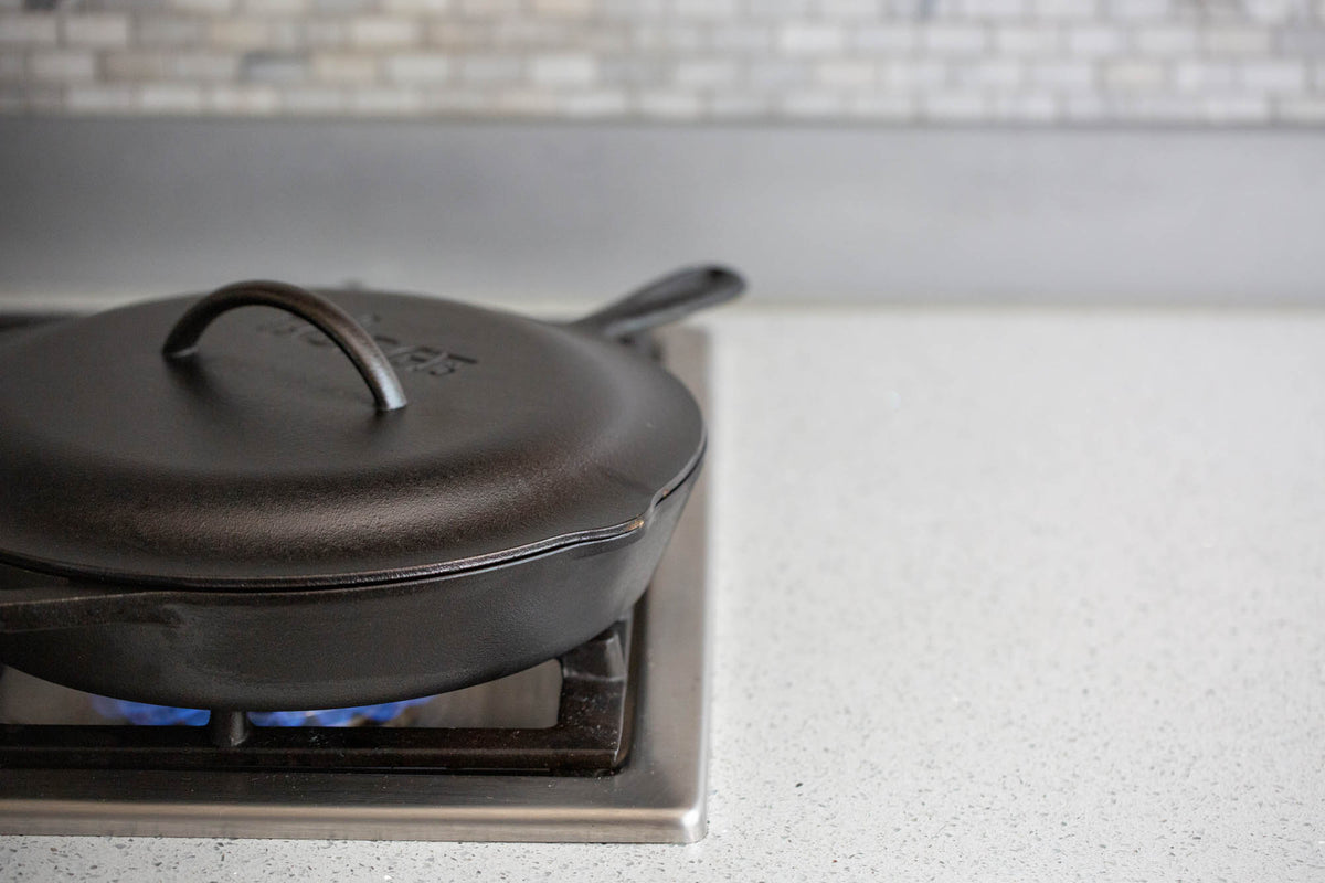 Black LODGE Classic lid for cookware, made of durable material, shown on a kitchen countertop.