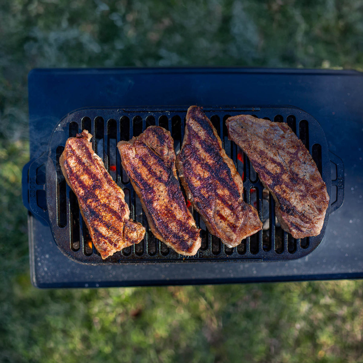 Lodge Sportsman’s Pro black outdoor grill with sturdy metal construction and large cooking surface.