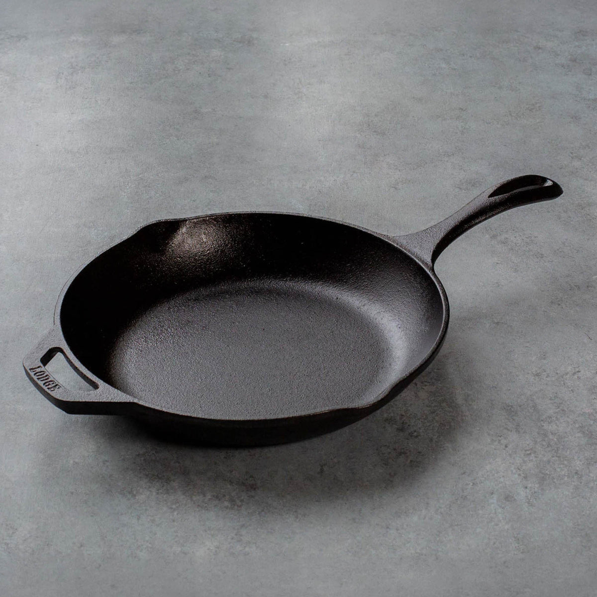 Lodge black cast iron pan, Chef series, showing a smooth cooking surface and sturdy handle for versatile kitchen use
