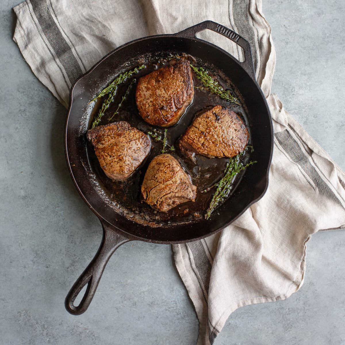 Lodge black cast iron skillet chef pan, front view showing smooth cooking surface and sturdy handle.