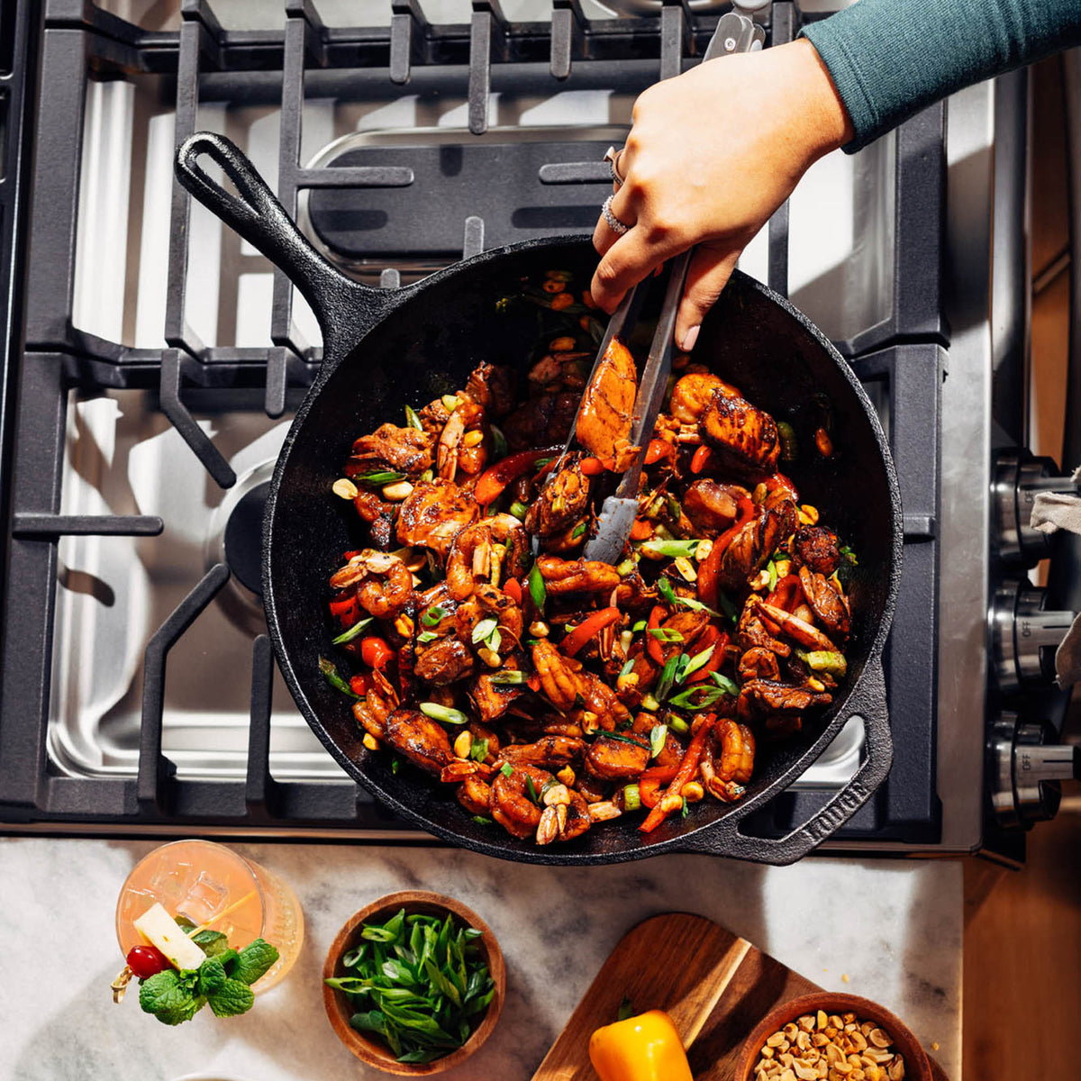 Black 32cm LODGE cast iron wok with chef handle, ideal for stir-frying and high-heat cooking in the kitchen.