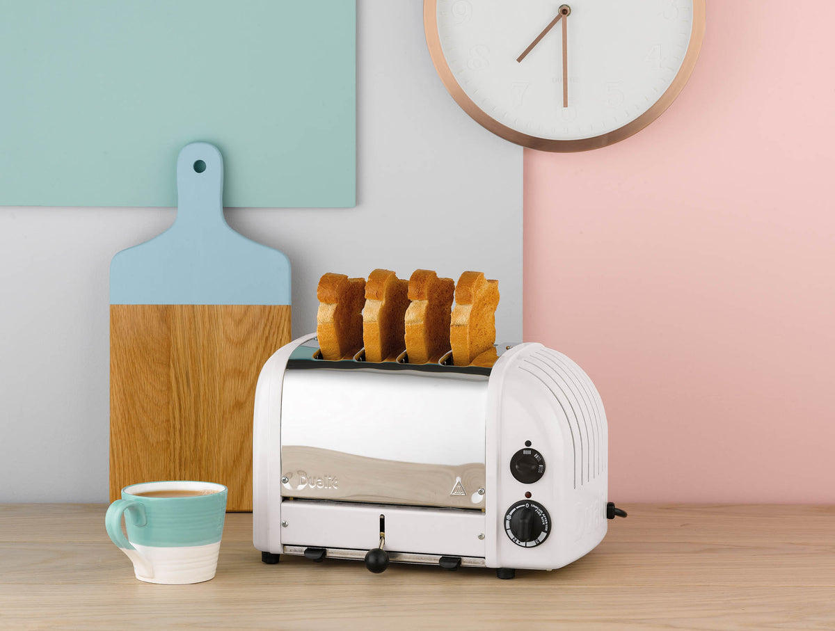 Dualit Newgen white 4-slice toaster with modern design and dial controls, shown with toasted bread slots open.