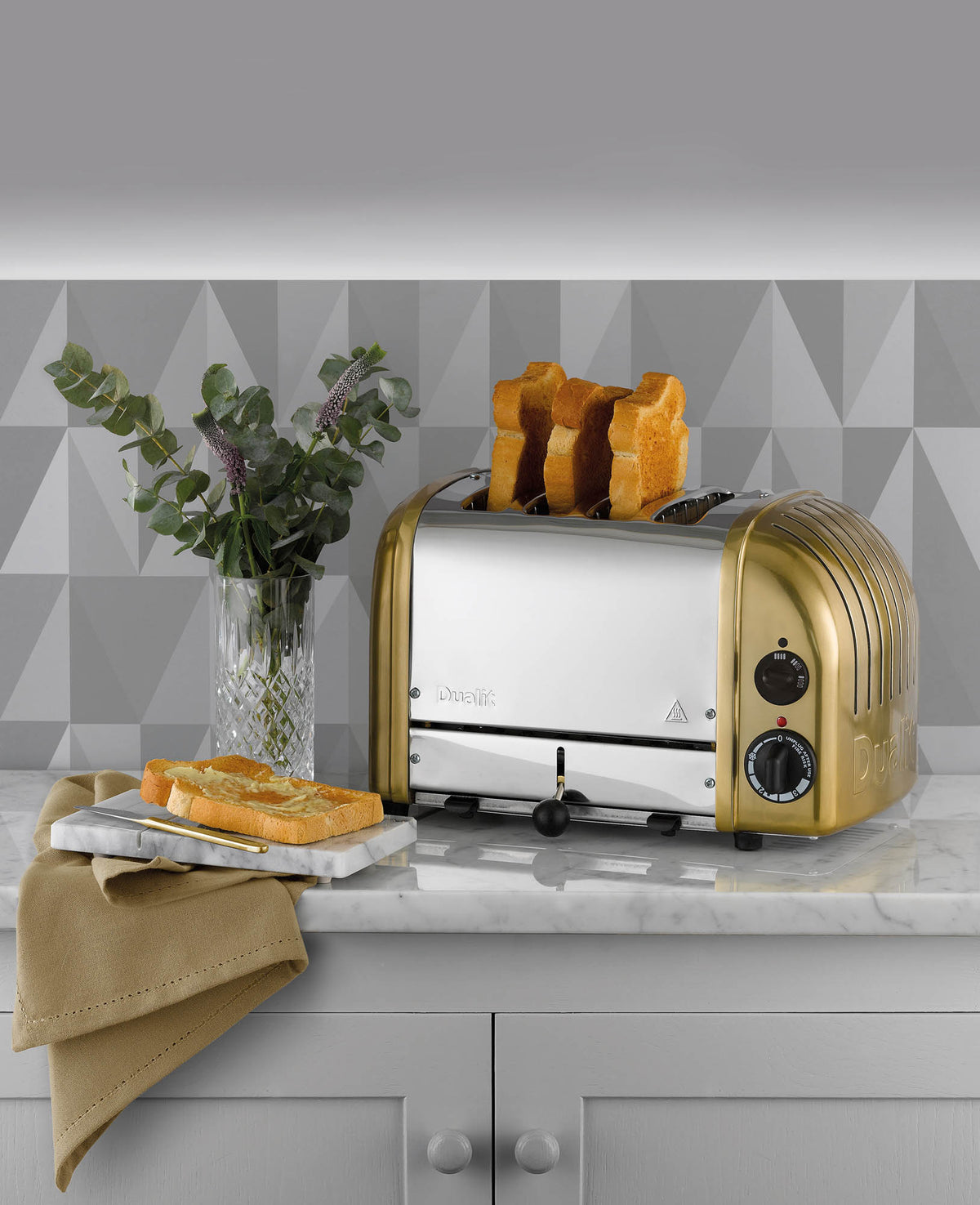 Dualit Newgen 4-slice toaster with metal finish, featuring toasting controls and slots for bread and bagels.
