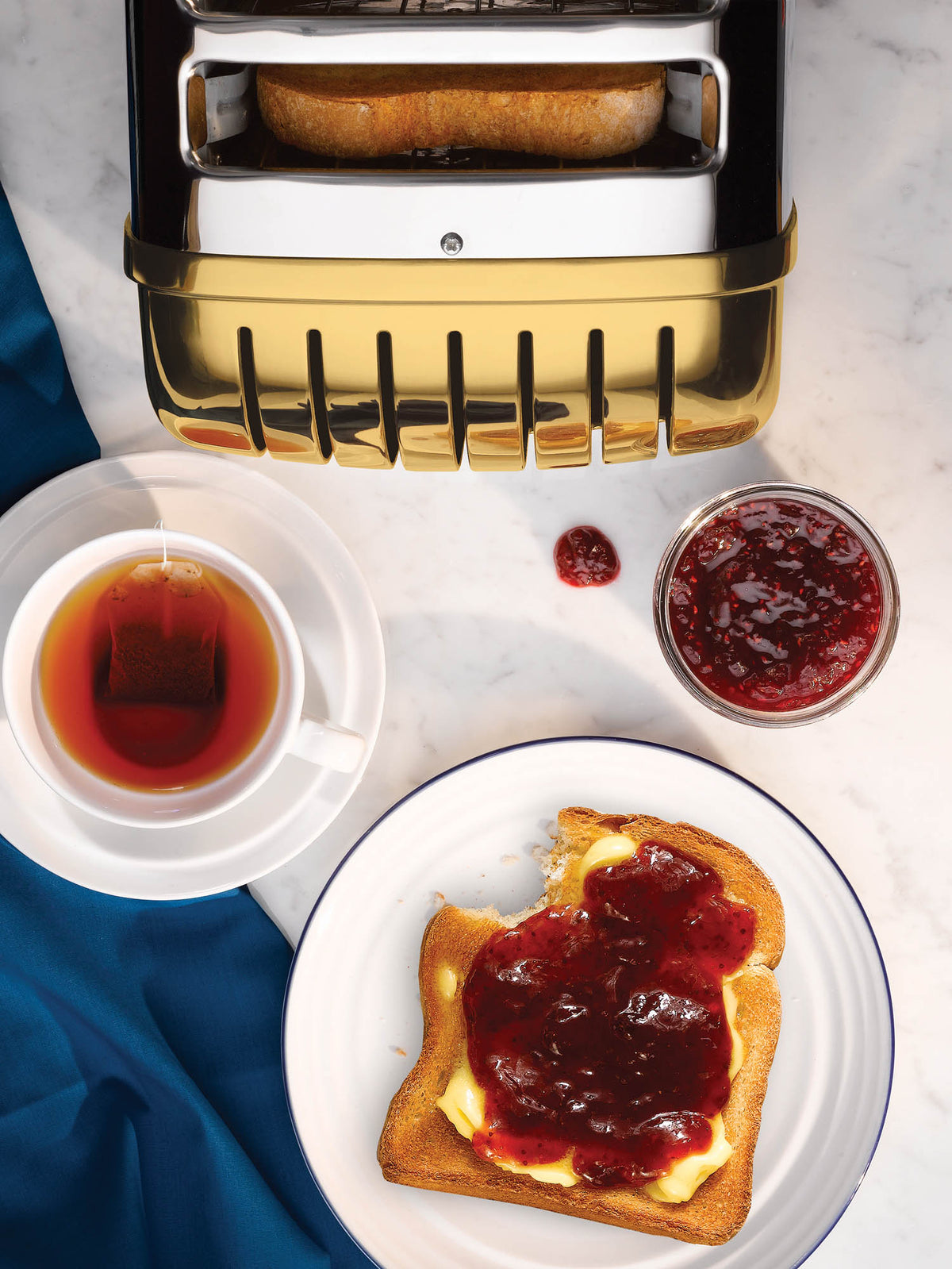 Dualit Newgen 4-slice toaster with metallic finish, featuring control knobs and slots for toasting bread evenly.
