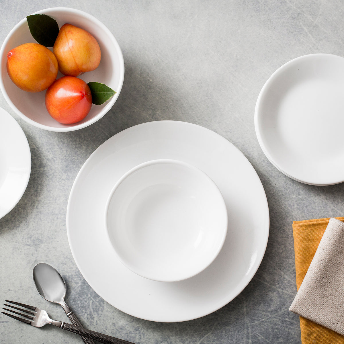 Corelle Winter Frost white dinnerware set, ceramic plates and bowls with a subtle frosted pattern on a clean white background.