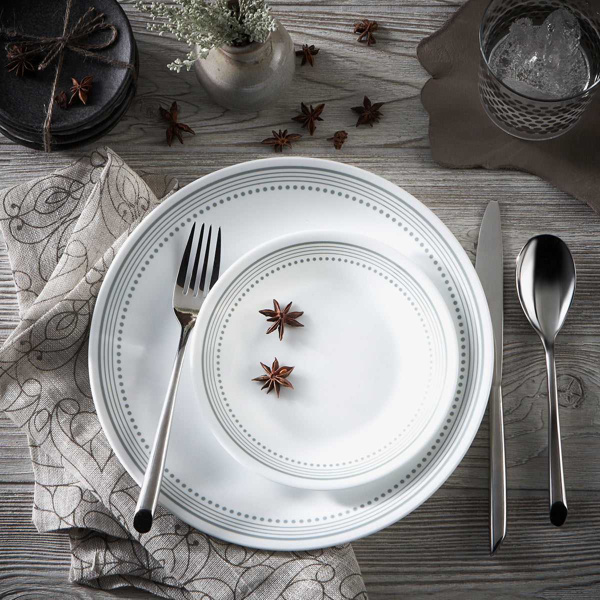 Corelle Mystic Gray dinnerware service with white plates and bowls, featuring a sleek, modern design for elegant table settings.