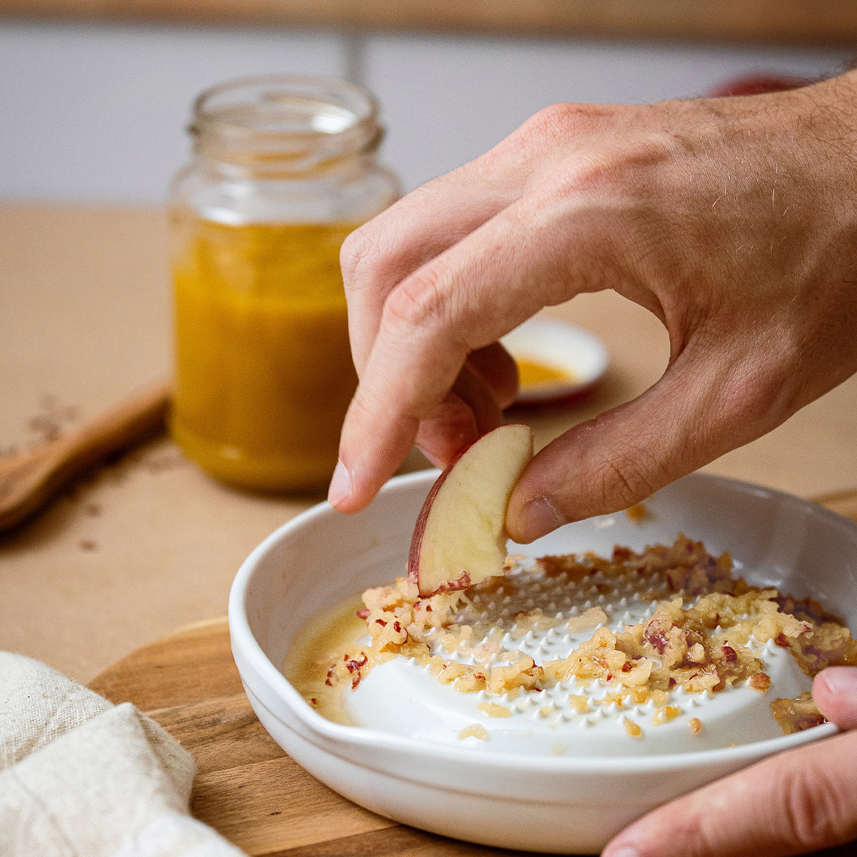 White KYOCERA ceramic grater, cylindrical kitchen tool with textured surface for fine food grating and zesting.