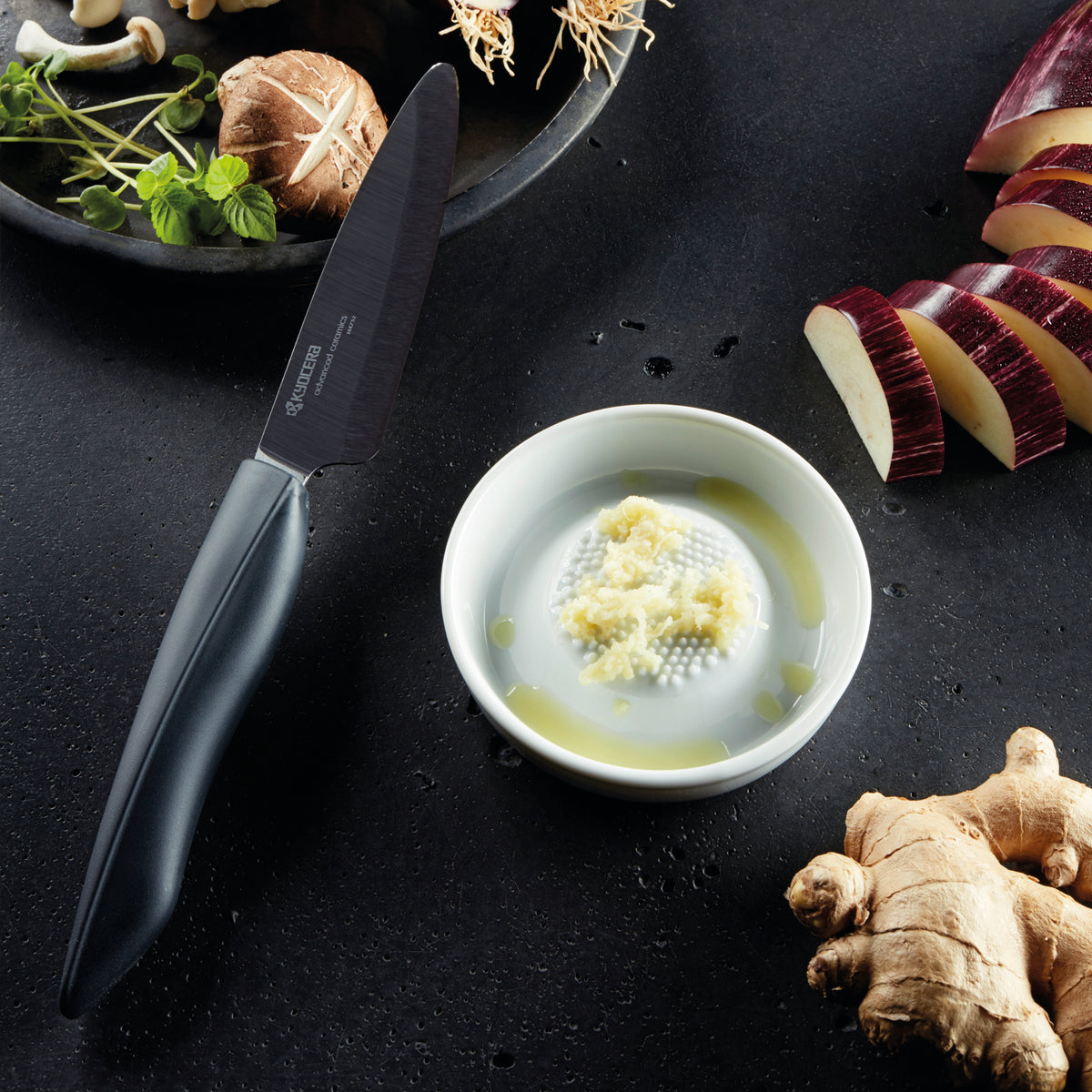 White KYOCERA ceramic grater for fine shredding of cheese, vegetables, and spices, with a durable, ergonomic handle.