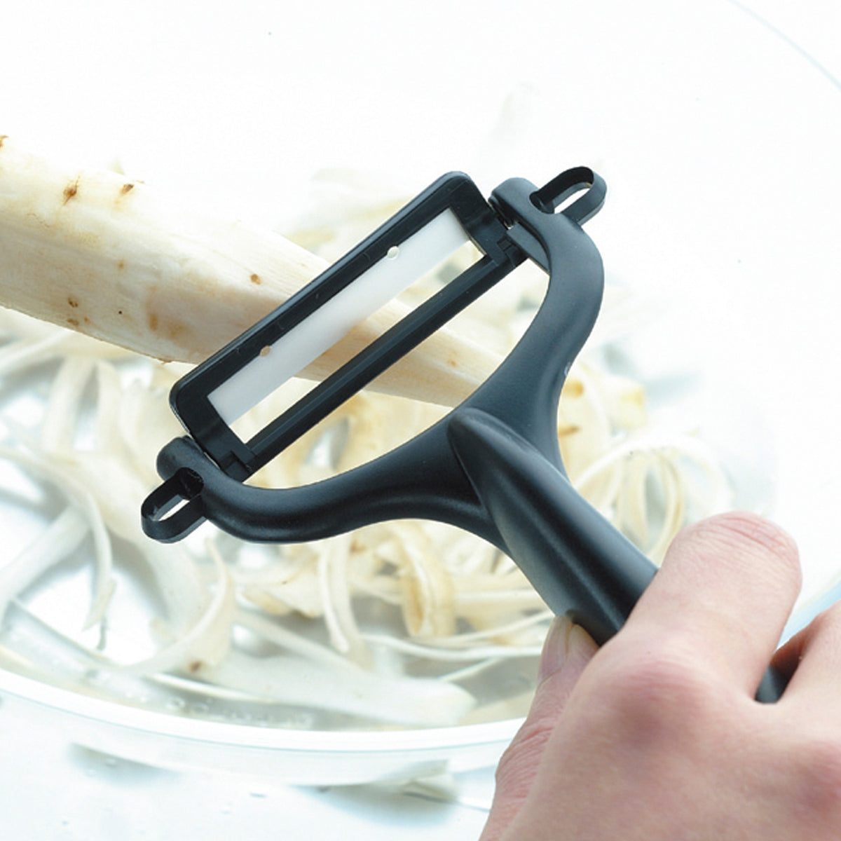 KYOCERA double-sided green vegetable peeler with sharp blades, ergonomic handle, ideal for peeling fruits and vegetables.