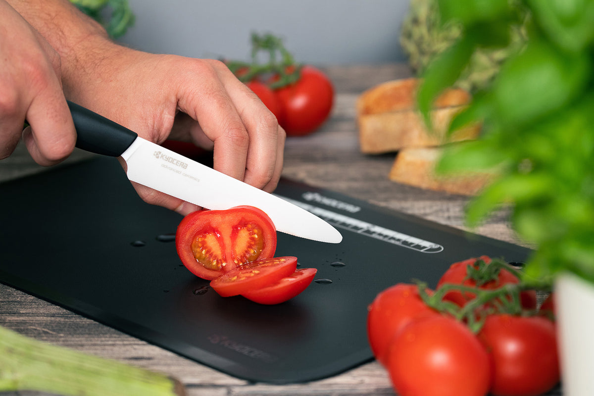 KYOCERA black ceramic knife, GEN series, sharp kitchen cutting tool with sleek black handle and blade.
