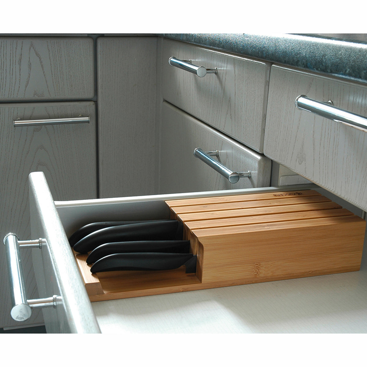 KYOCERA 3-in-1 bamboo knife block with multiple slots for kitchen knives and utensils, showcasing its sleek, natural design.