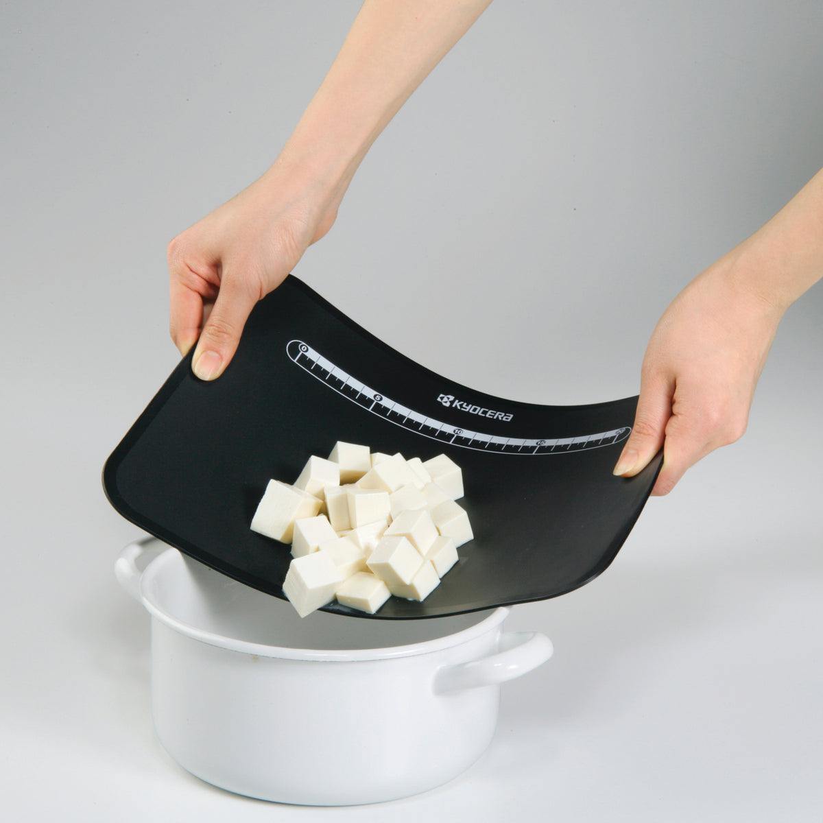 Flexible black KYOCERA cutting mat, 37 x 25 cm, ideal for precise slicing and protecting surfaces during craft or kitchen tasks.