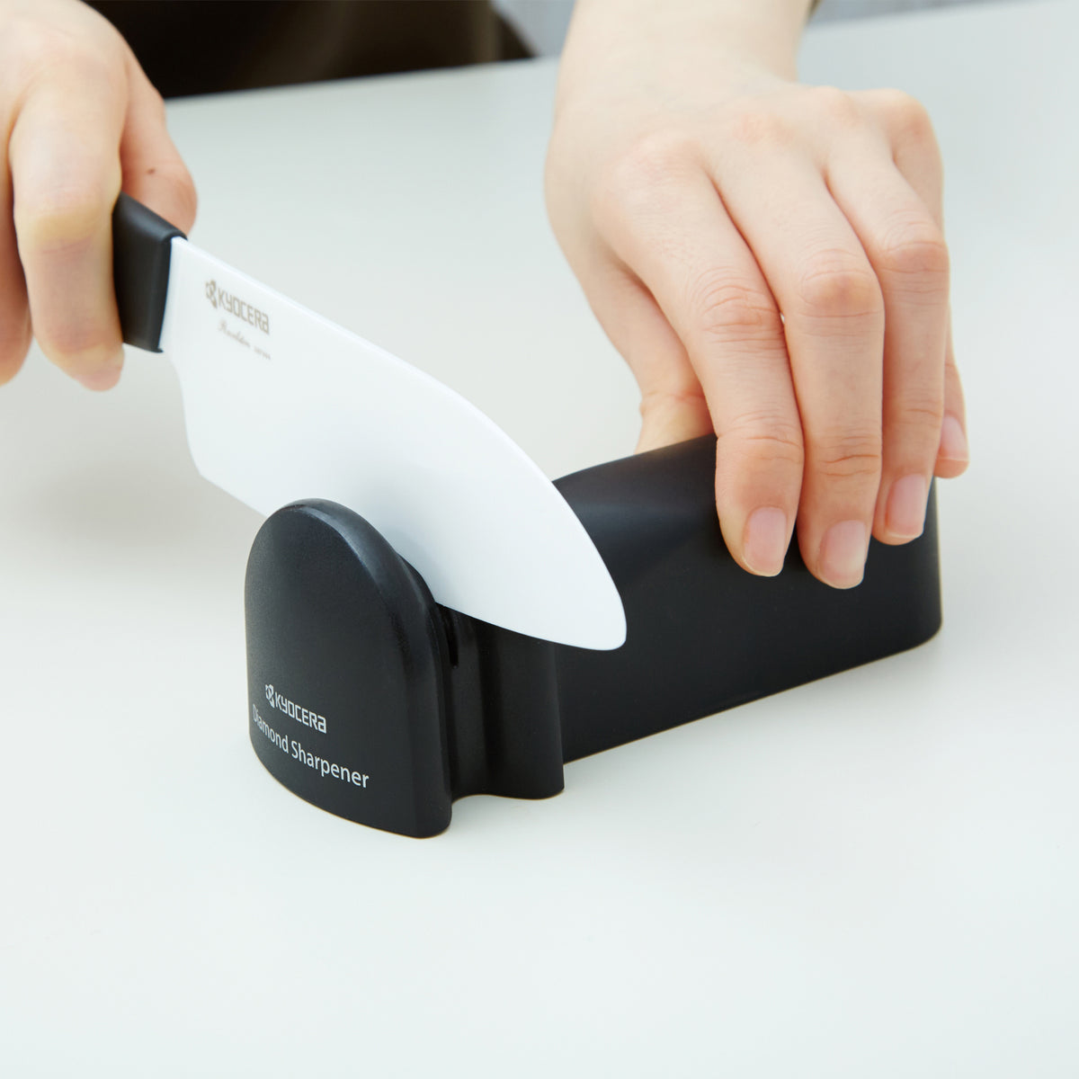 KYOCERA ceramic and steel knife sharpener with ergonomic handle and compact design for easy sharpening.