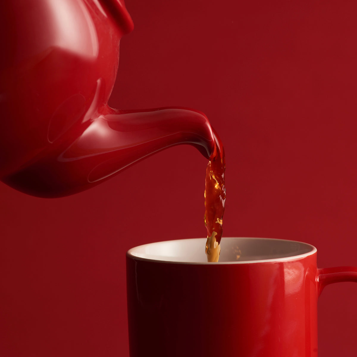 Red P & K Kensington teapot from Price & Kensington with 10 cups, traditional ceramic tea set on a white background.