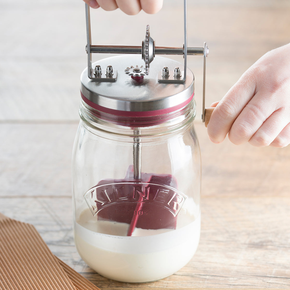 KILNER 1L clear butter churn with wooden handle and glass body, used for making homemade butter.