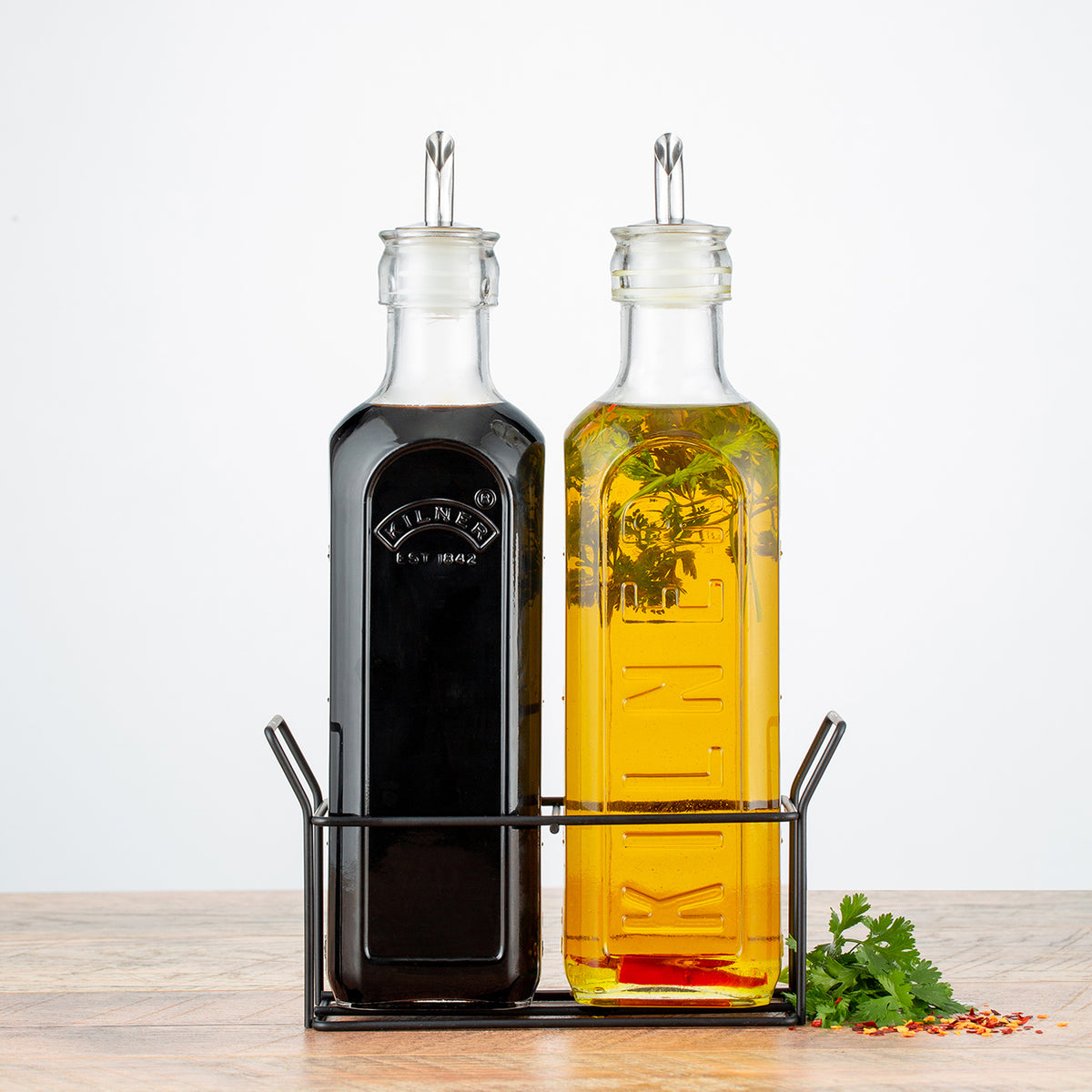 Clear glass KILNER oil and vinegar bottles with stoppers, ideal for storing and pouring oils or vinegars in the kitchen.