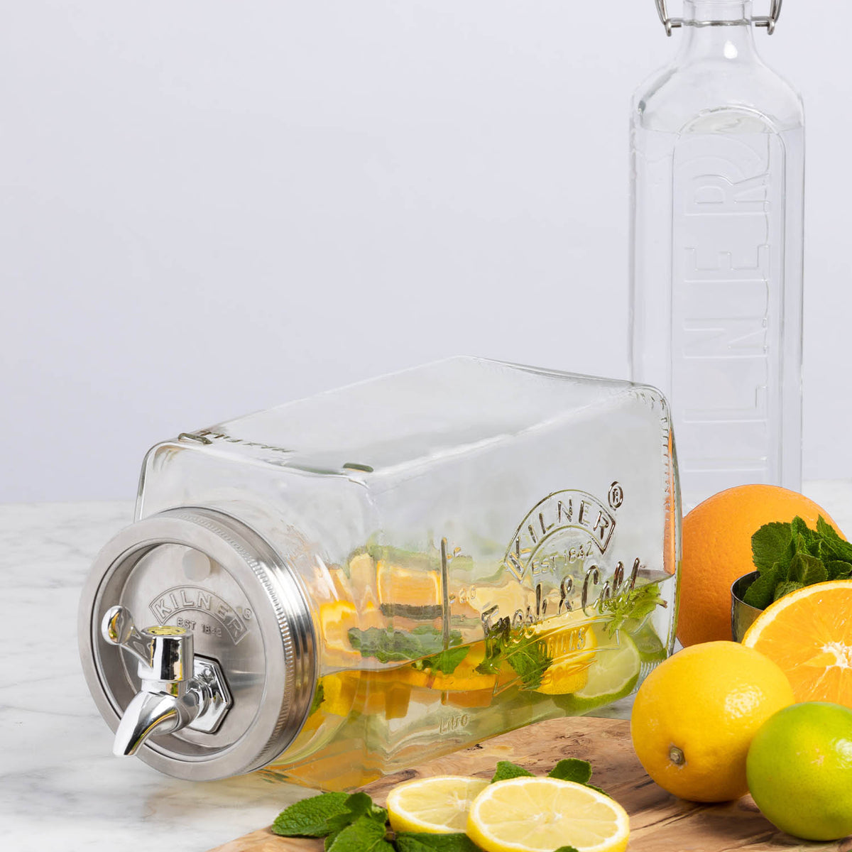 KILNER 3L clear and silver beverage dispenser for fridge, with a spout for easy pouring and a secure lid.