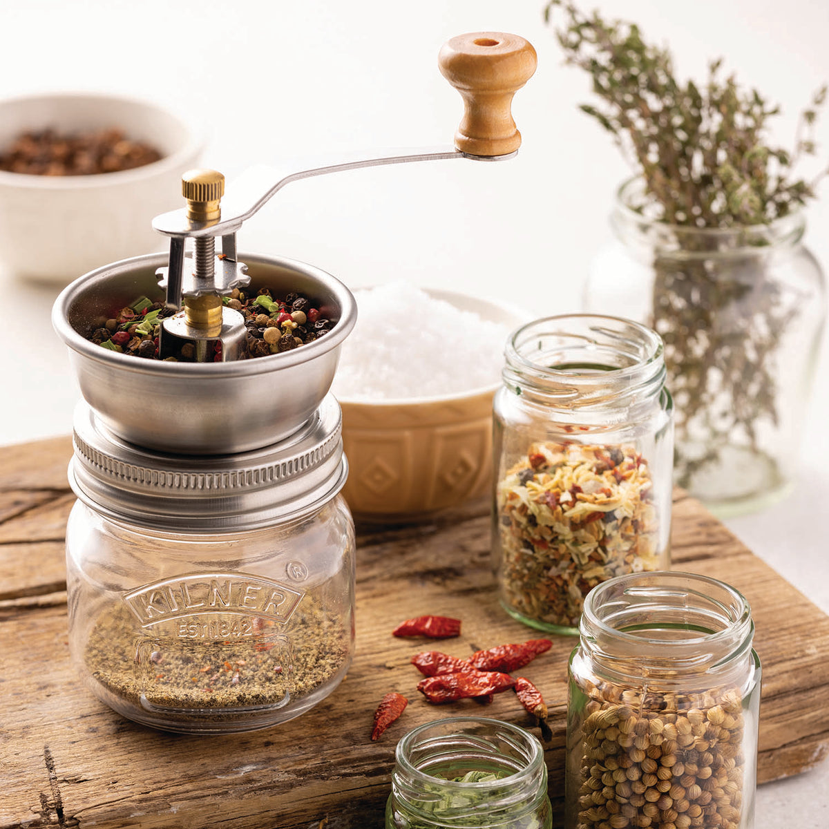 KILNER spice grinder in clear 250 ml glass jar with stainless steel lid, filled with mixed spices for grinding.