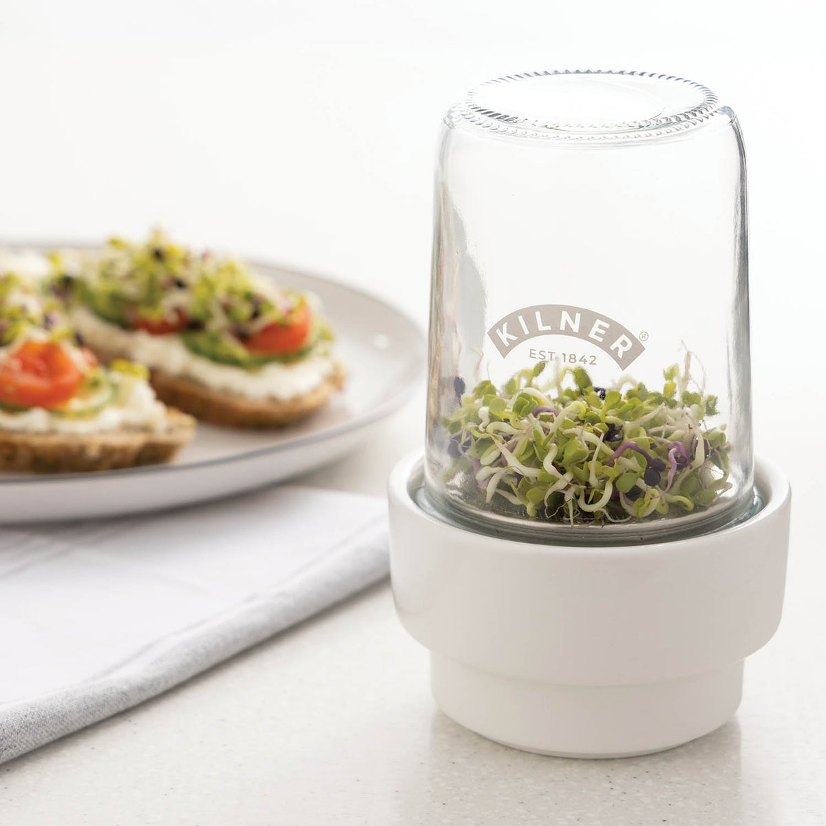KILNER Kräuter-Frischeglas 500 ml glass jar for fresh herbs, with a metal lid and transparent body showing herbs inside.