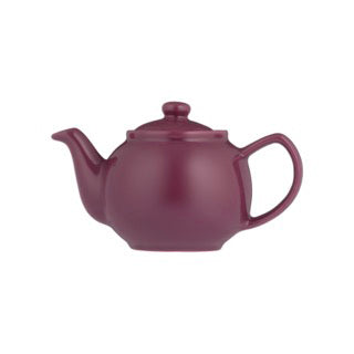 Teekanne P & K mint plum tea in a teapot, with fresh mint leaves and plum flavor, on a cozy wooden table.