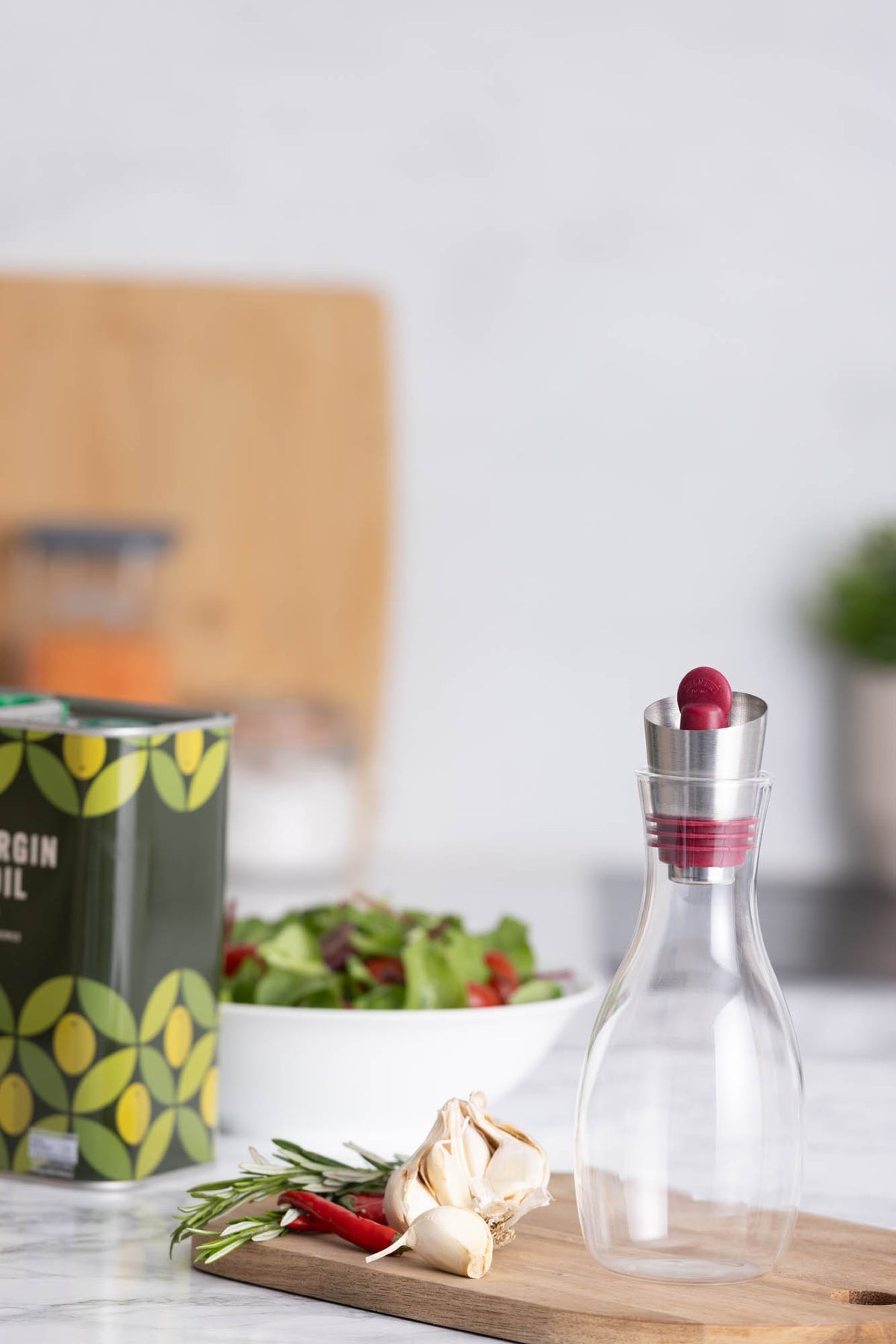 Glass oil bottle with built-in sieve from KILNER, featuring a clear design and metal lid for easy pouring and storage.