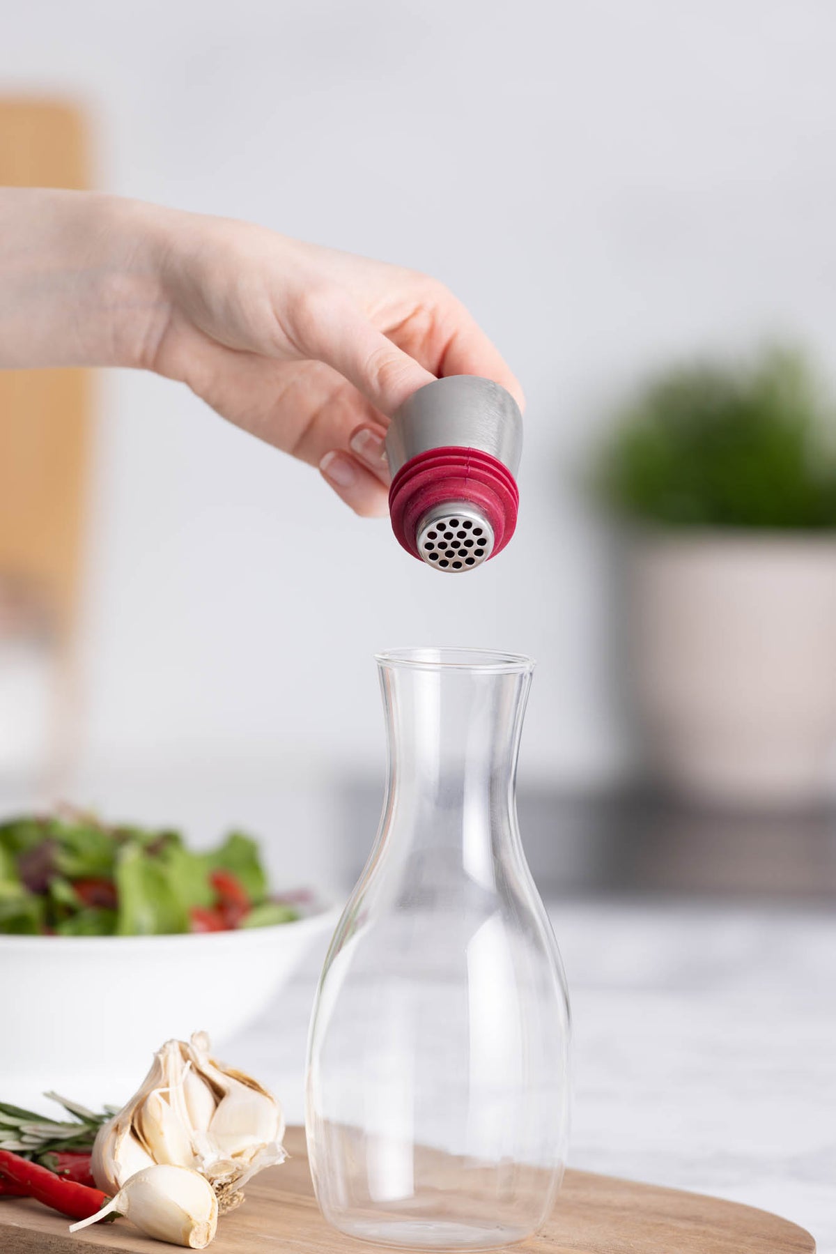 Glass oil bottle with built-in strainer from KILNER, featuring a clear design for easy pouring and filtering oils.