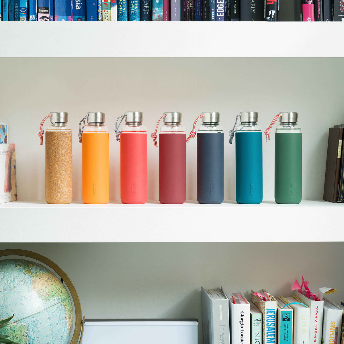 BLACK+BLUM TO-GO GLAS water bottle in ocean blue, 600ml, with clear glass body and black lid, portable and reusable.
