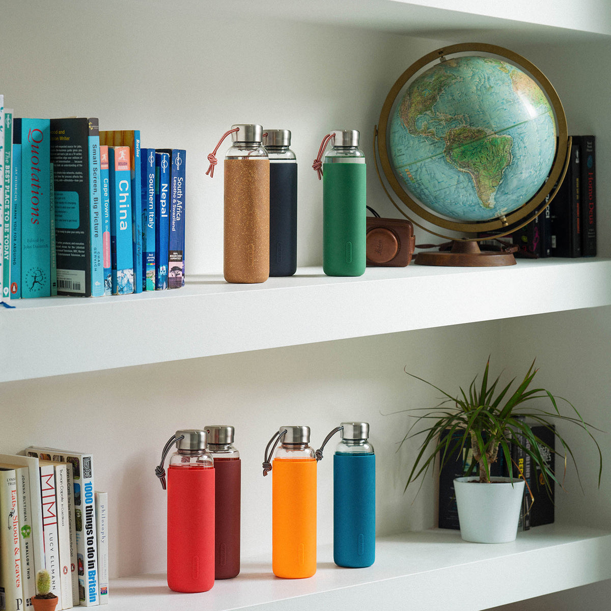 BLACK+BLUM TO-GO GLAS water bottle in ocean blue, 600 ml, with a clear glass body and black screw cap for portable hydration.