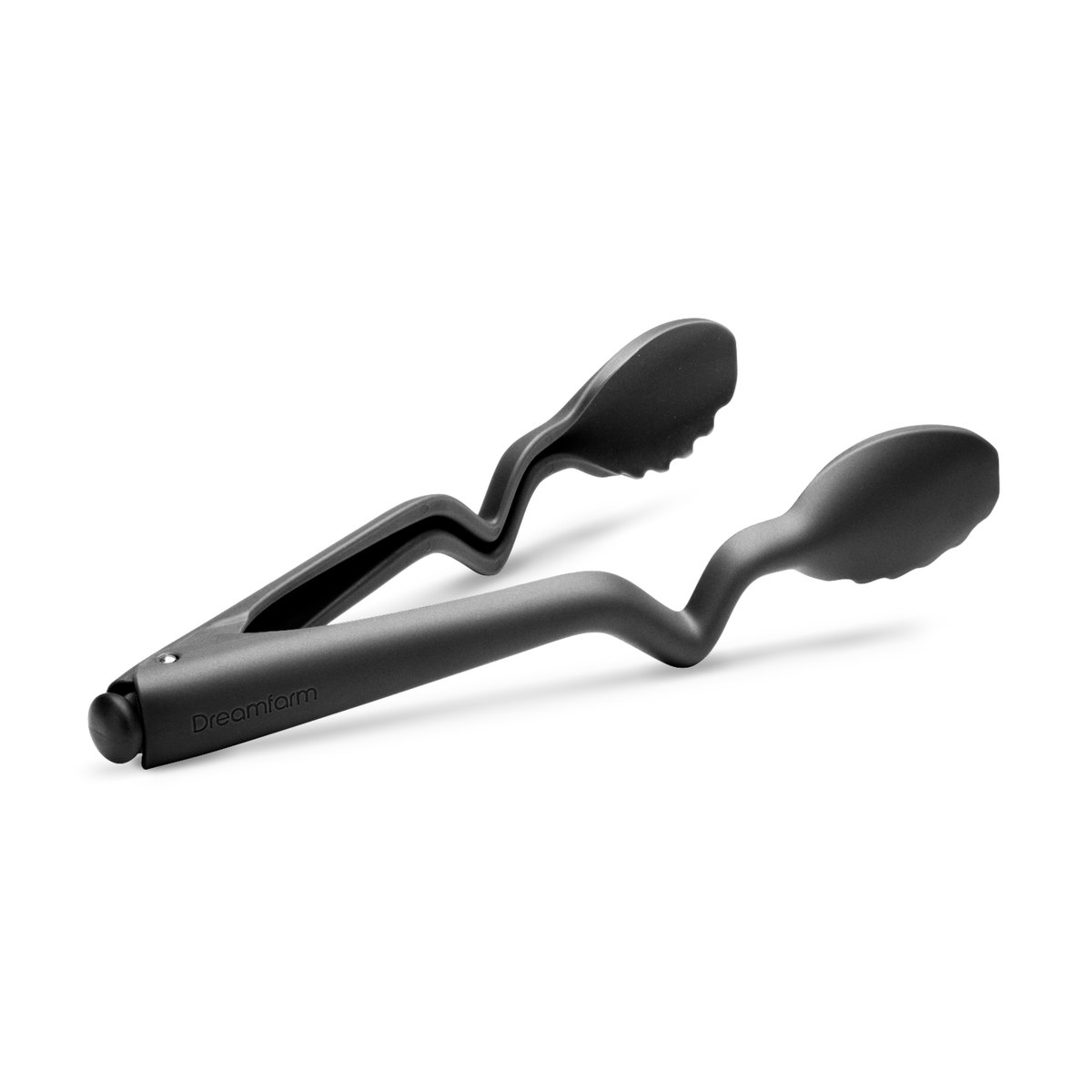 DREAMFARM black kitchen tongs, CLONGS style, with stainless steel tips for grilling and cooking, held open in a kitchen setting.