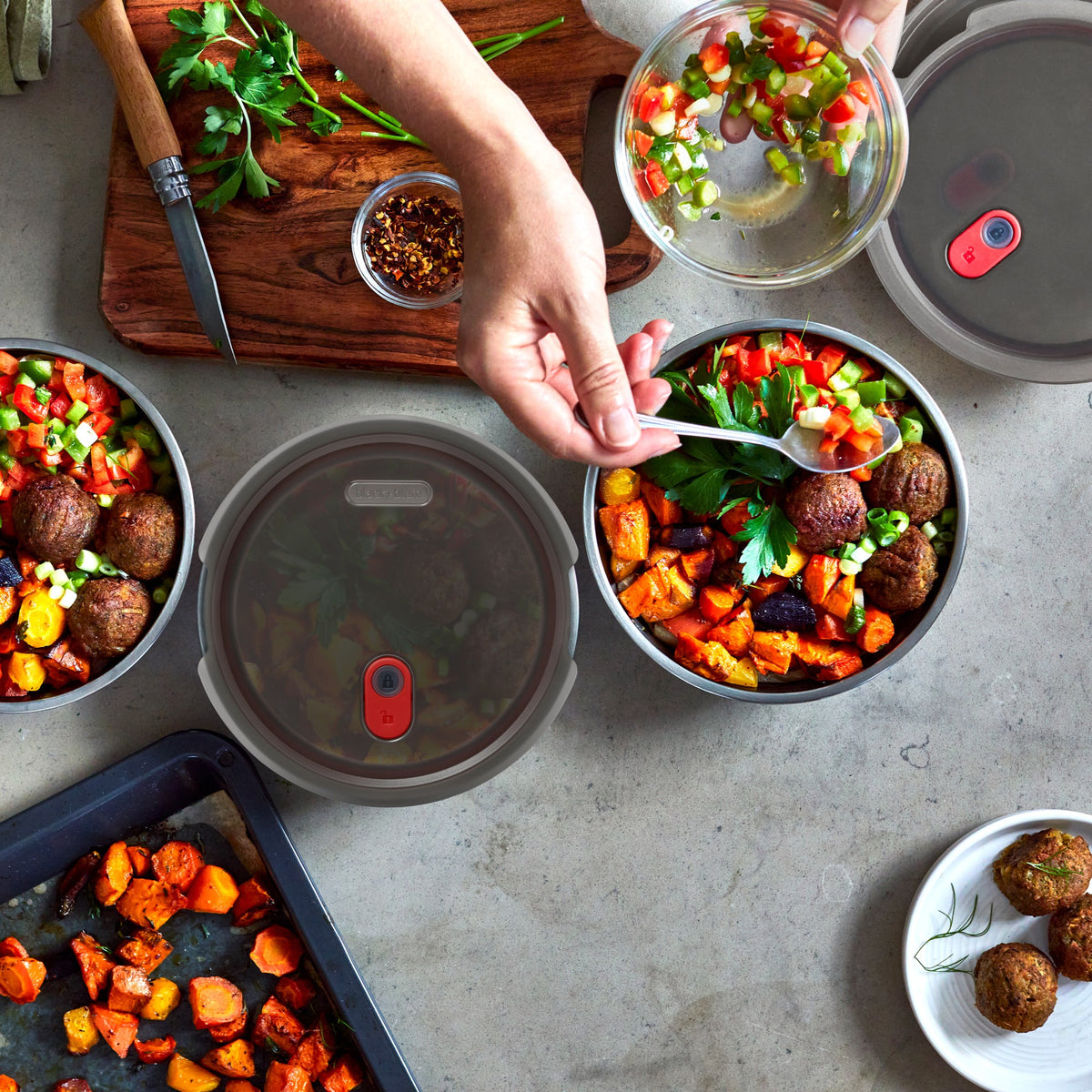 Black+Blum stainless steel multifunctional storage box with three small bowls and lid, shown in a flatlay with people.