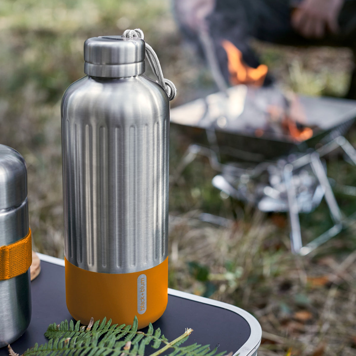 BLACK+BLUM Explorer insulated bottle in orange, showing the sleek design and secure cap, ideal for camping and outdoor use.