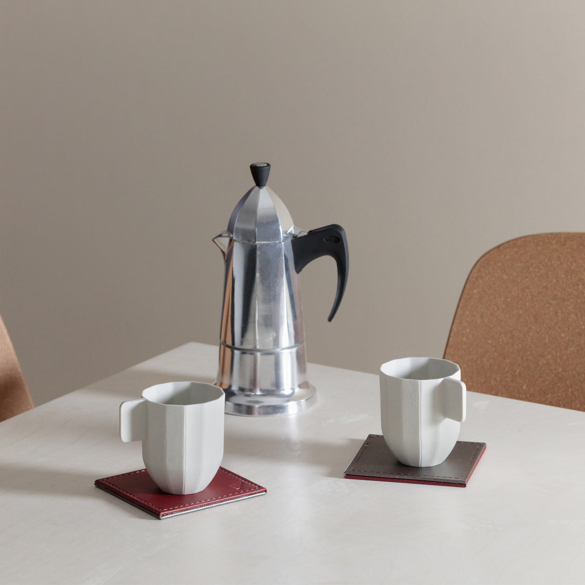 Set of four FREEFORM DUO coasters with modern design, made of durable material, displayed on a wooden surface.