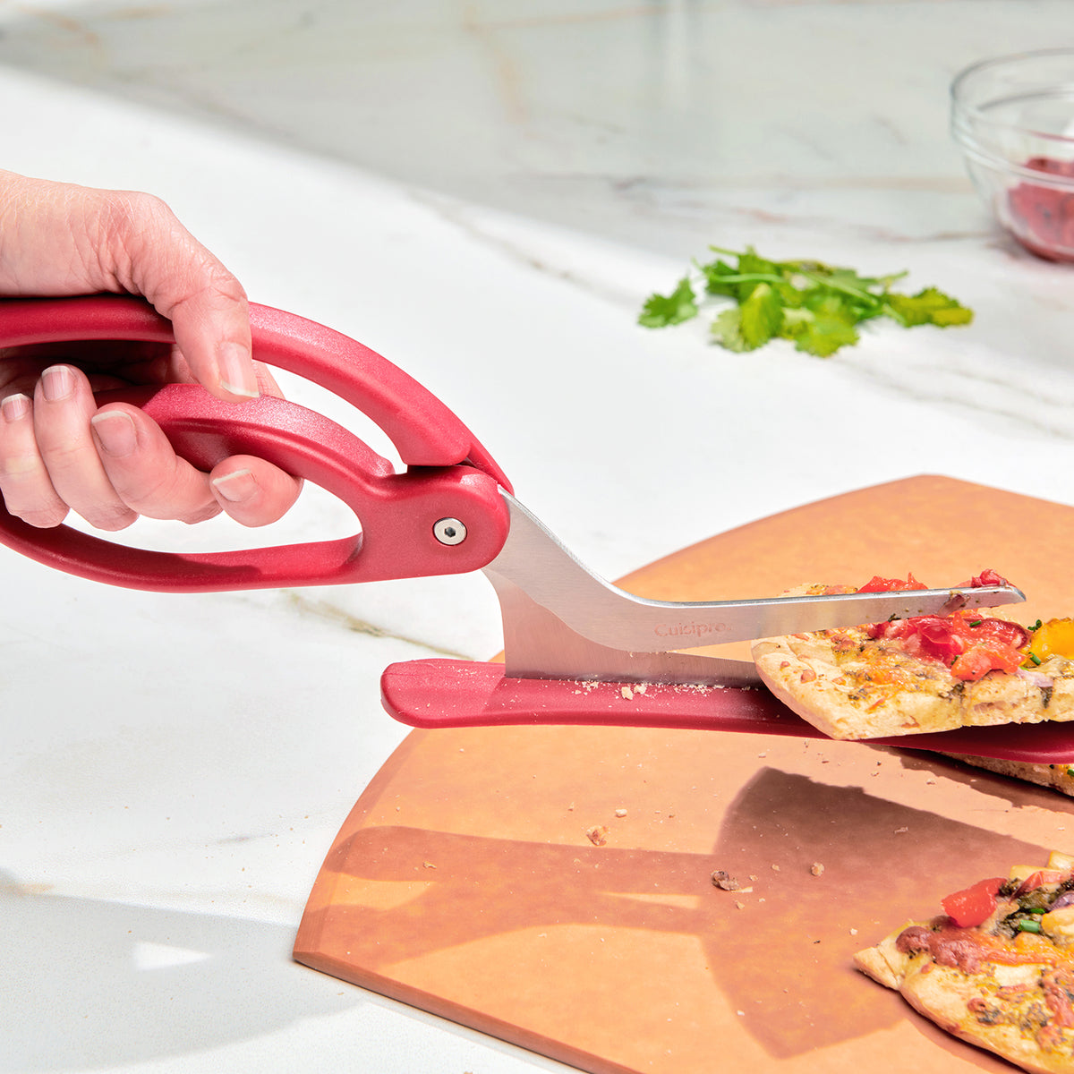 CUISIPRO pizza cutter in red with a round blade, designed for slicing pizzas easily and efficiently.