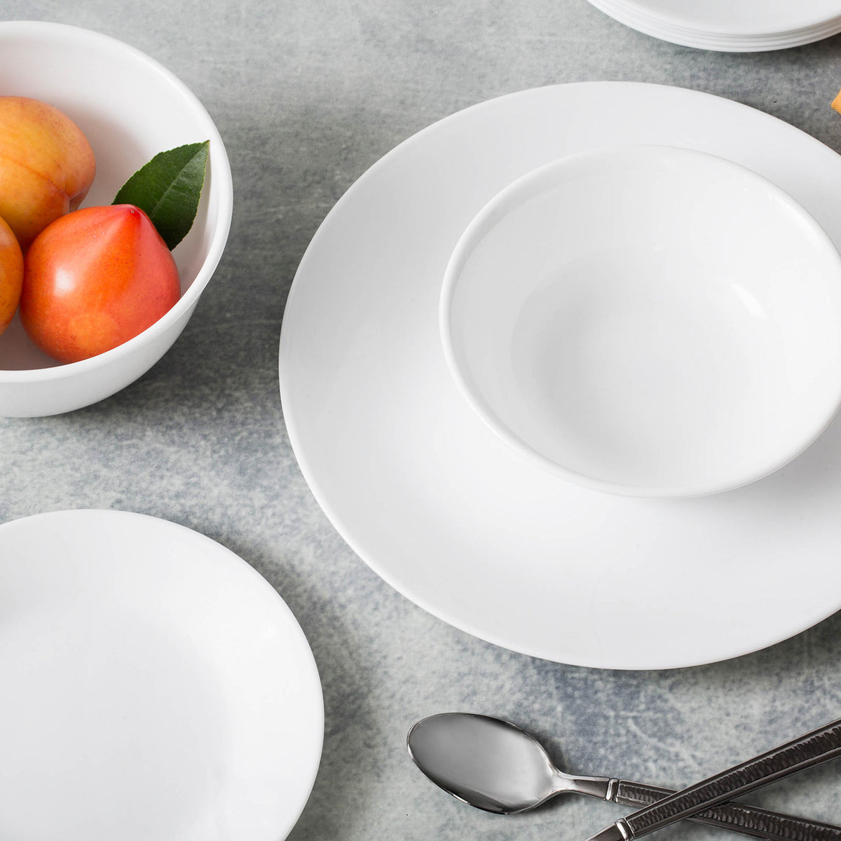 Corelle Winter Frost white dinnerware set featuring plates and bowls with a frosted snowflake design on ceramic dishes.