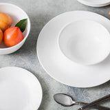 Corelle Winter Frost white dinnerware set featuring plates and bowls with a frosted snowflake design on ceramic dishes.