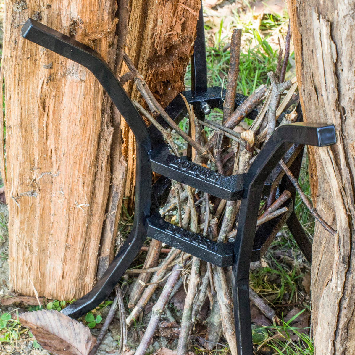 Black LODGE Fire & Cook grill stand with sturdy metal construction, designed for outdoor cooking and grilling.
