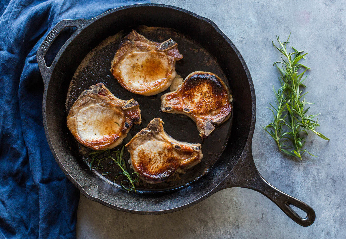 Black LODGE cast iron skillet, classic design, showing the smooth cooking surface and sturdy handle.