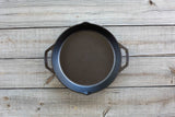 Lodge classic cast iron skillet in black, showing a sturdy, seasoned cooking pan with a handle and cooking surface.