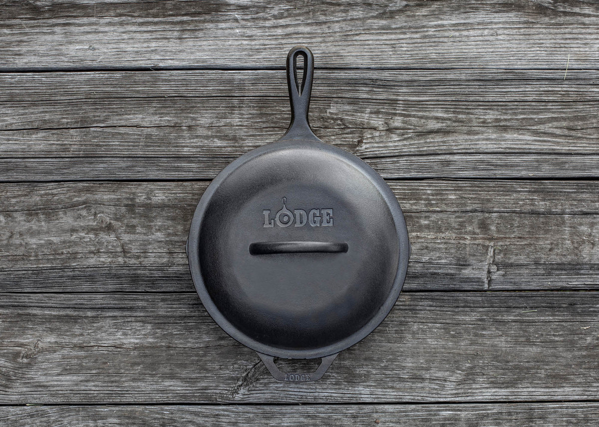 Black LODGE Classic lid for cookware, shown resting on a stove or cookware surface. Durable and heat-resistant kitchen accessory.