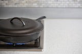 Black LODGE Classic lid for cookware, made of durable material, shown on a kitchen countertop.