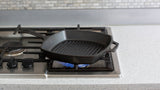 Lodge square black grill pan with handle and textured cooking surface, 26.7 cm diameter for grilling and searing.