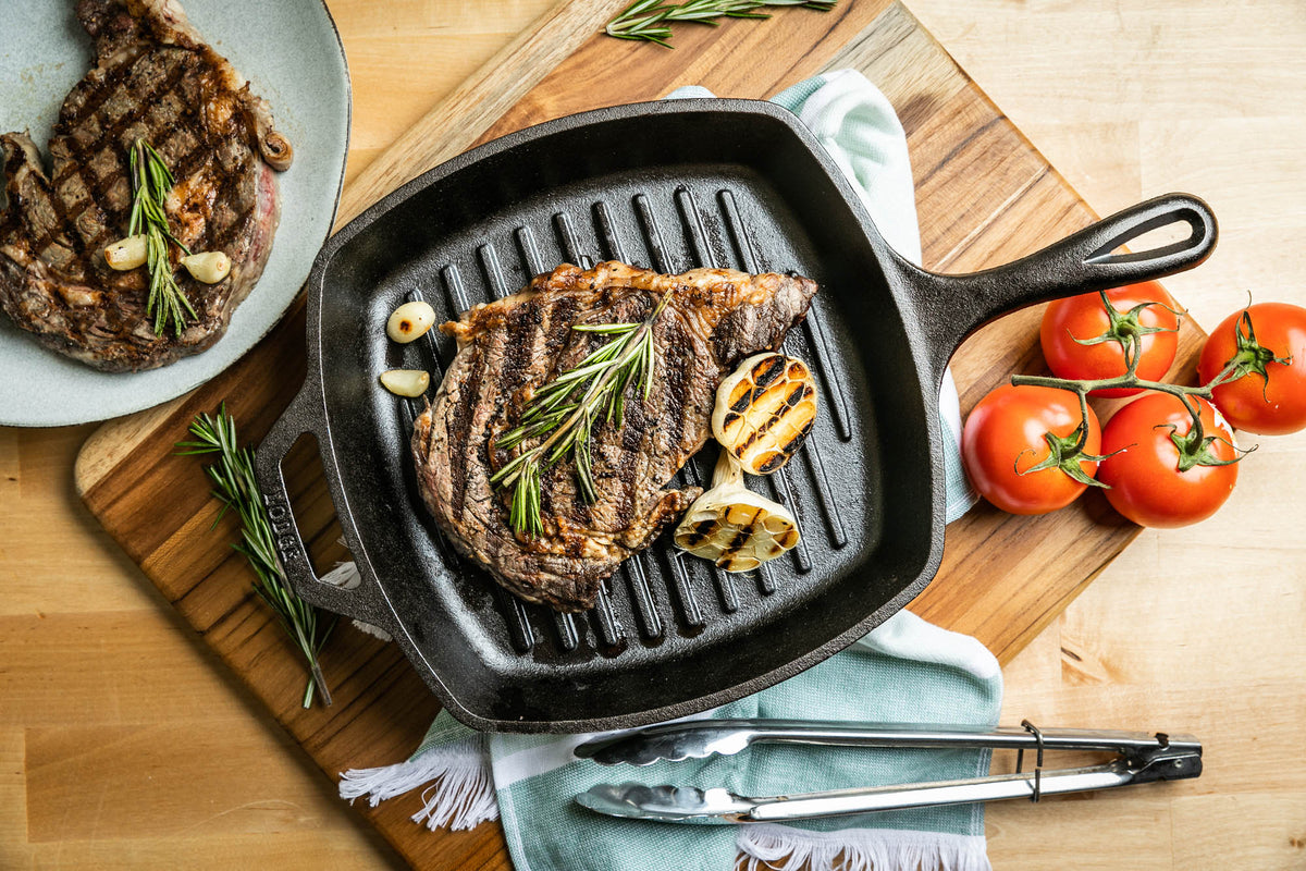 Lodge Classic square black cast iron grill pan with 26.7 cm diameter, suitable for indoor and outdoor grilling.