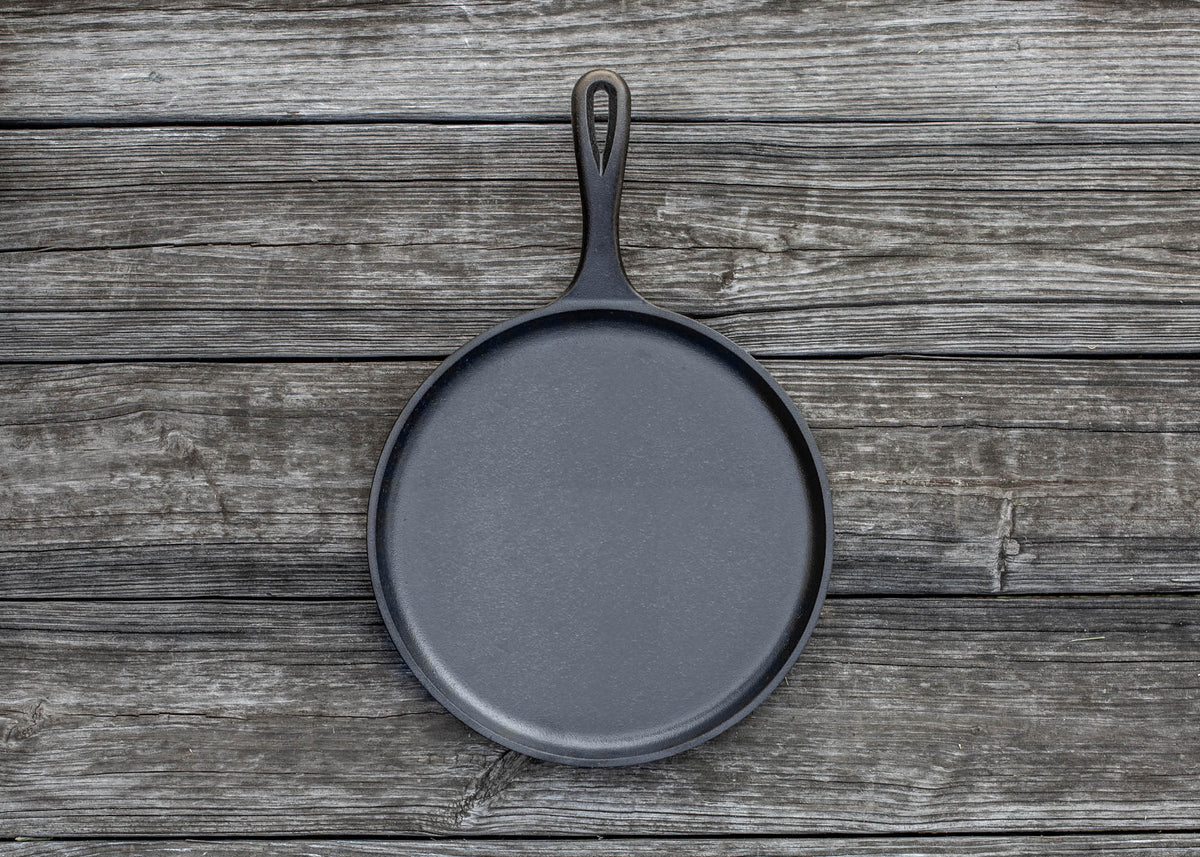 Lodge Classic black flat grill pan with a 26.7 cm diameter, ideal for grilling and searing on the stovetop.