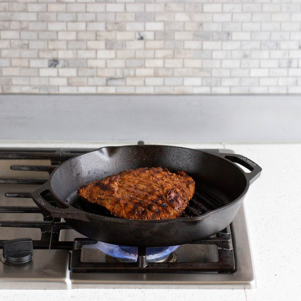 Lodge Classic black double-handle grill pan with 30.5 cm diameter for outdoor or indoor grilling.