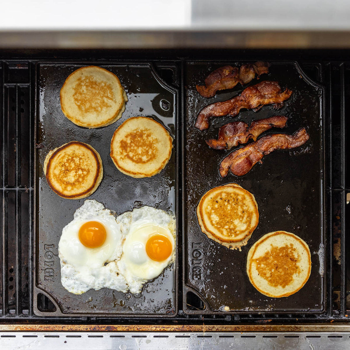 Lodge 2-sided black Classic Grillplatte, 42.5 cm, showing both flat and ridged cooking surfaces for versatile grilling.