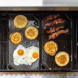 Lodge 2-sided black Classic Grillplatte, 42.5 cm, showing both flat and ridged cooking surfaces for versatile grilling.