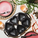 Lodge Classic black 6-heart cake pan, durable bakeware for creating shaped cakes with non-stick surface.