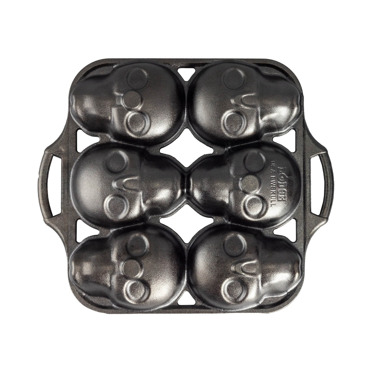 Lodge black cake mold with six skull-shaped cavities for baking creative skull-themed desserts.